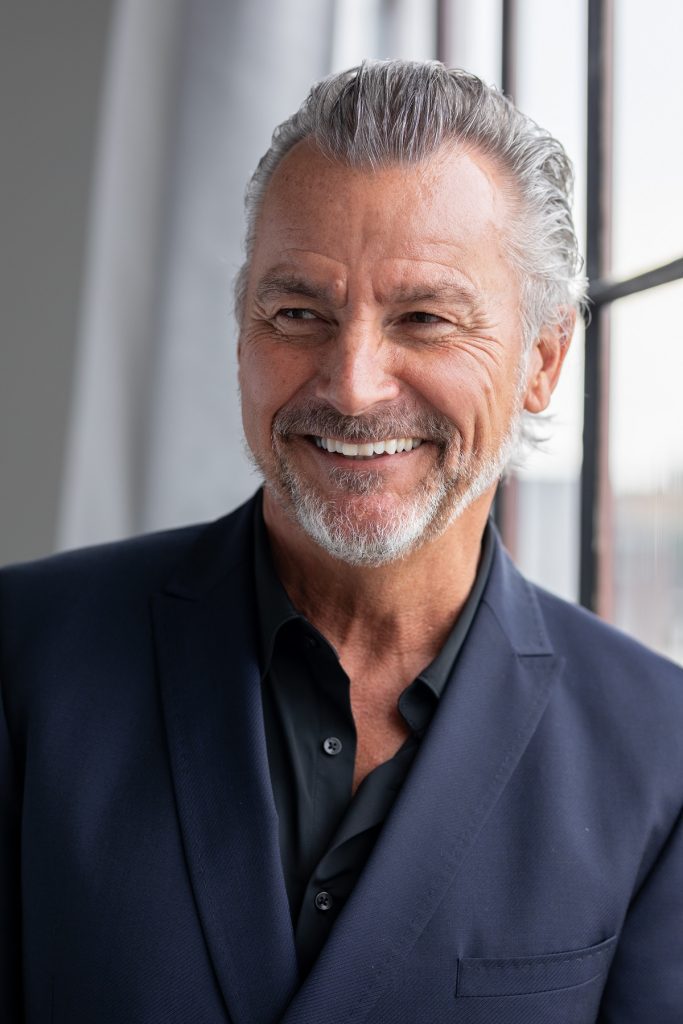 A man with grey hair and a black shirt