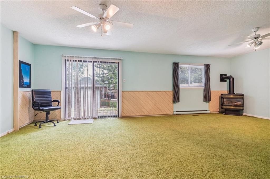 A living room with green carpet and a piano.