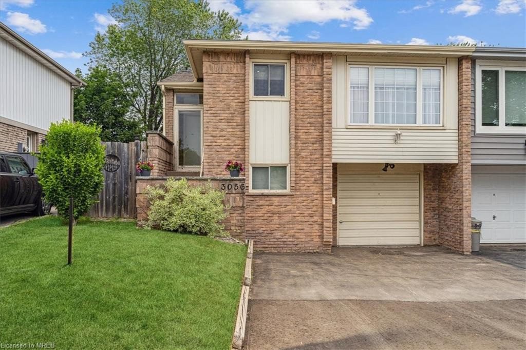 A brick house with a driveway and garage.