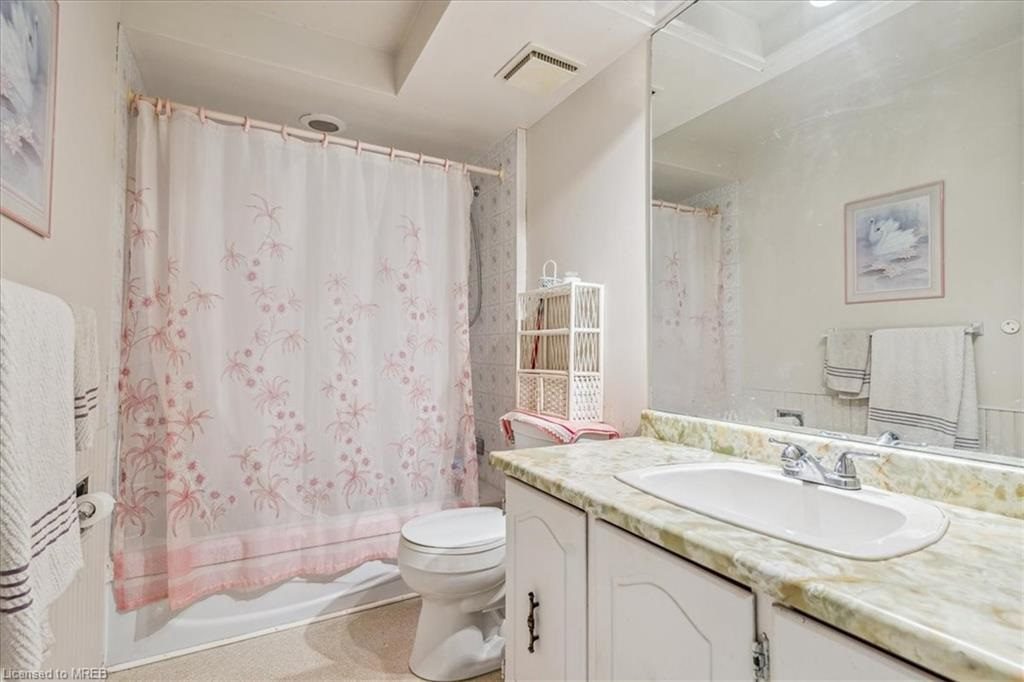 A bathroom with a toilet, sink and shower.