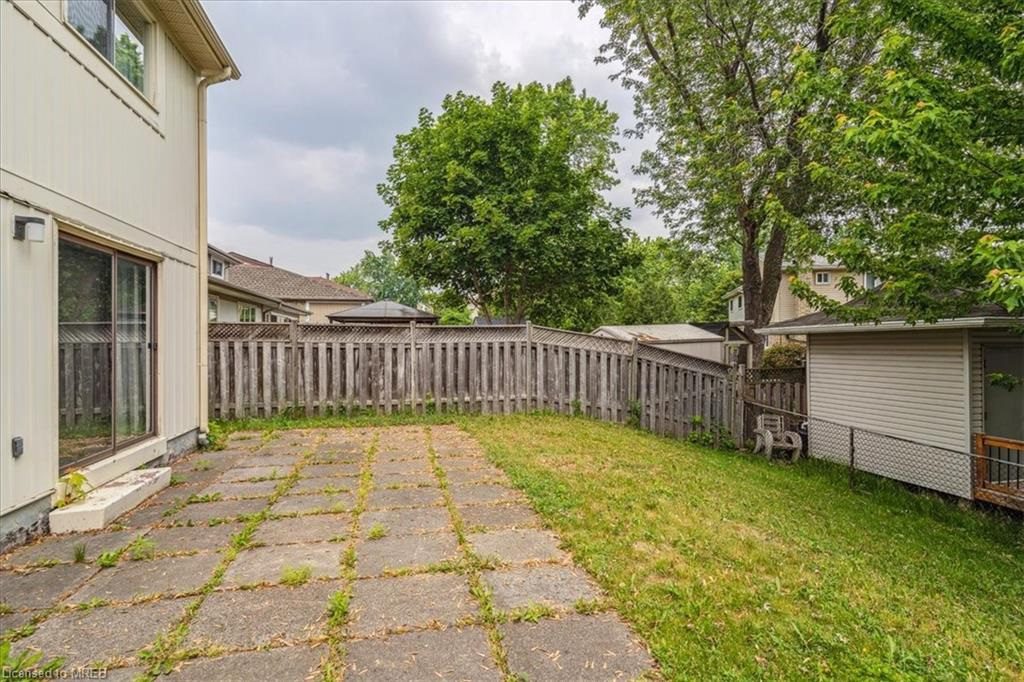 A backyard with grass and trees in the background.