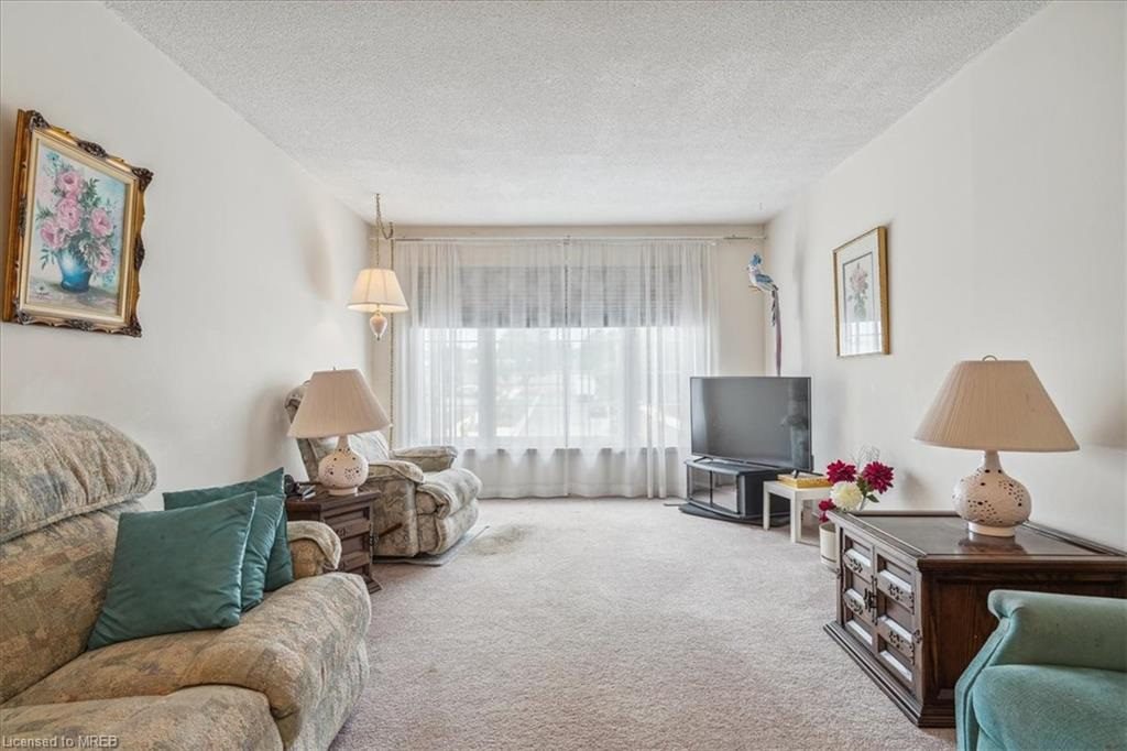 A living room with a couch, chair and television.