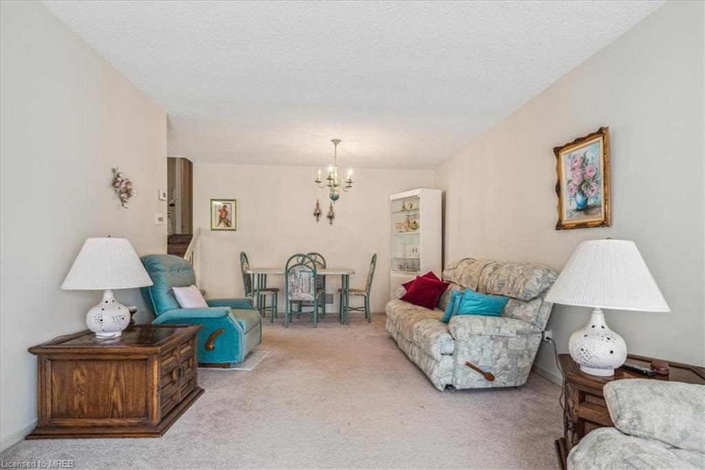 A living room with couches, chairs and tables.