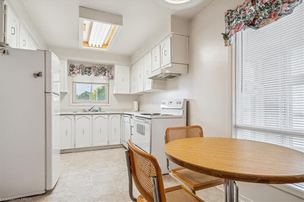 A kitchen with white cabinets and wooden table.