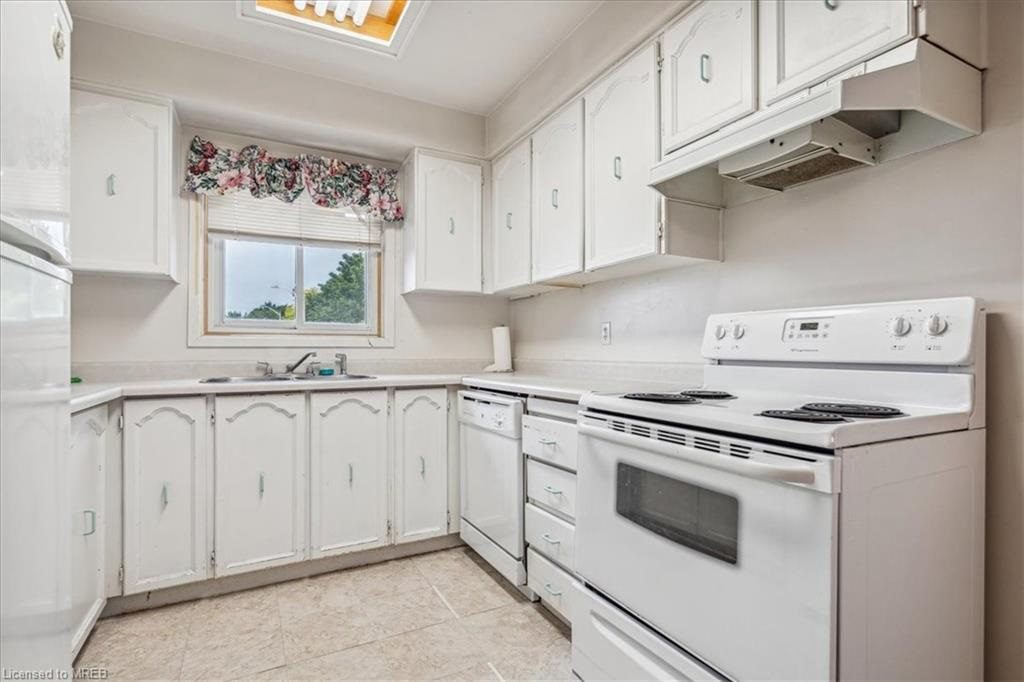 A kitchen with white cabinets and appliances in it