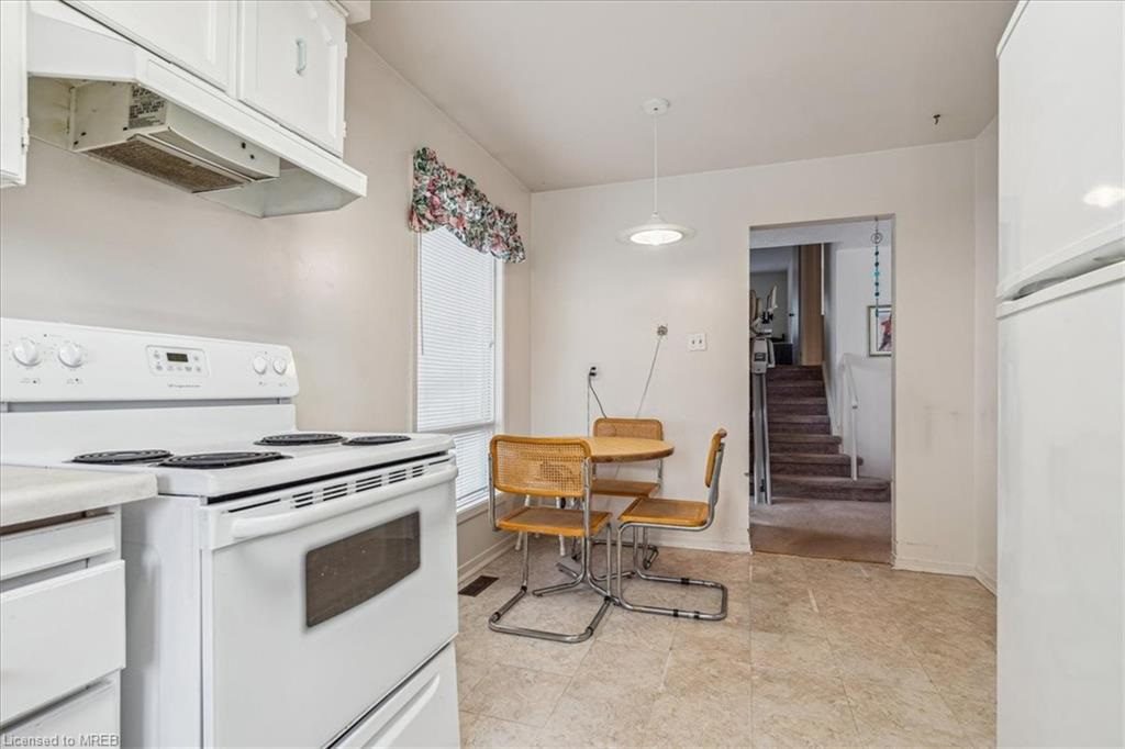 A kitchen with white appliances and tile floors.