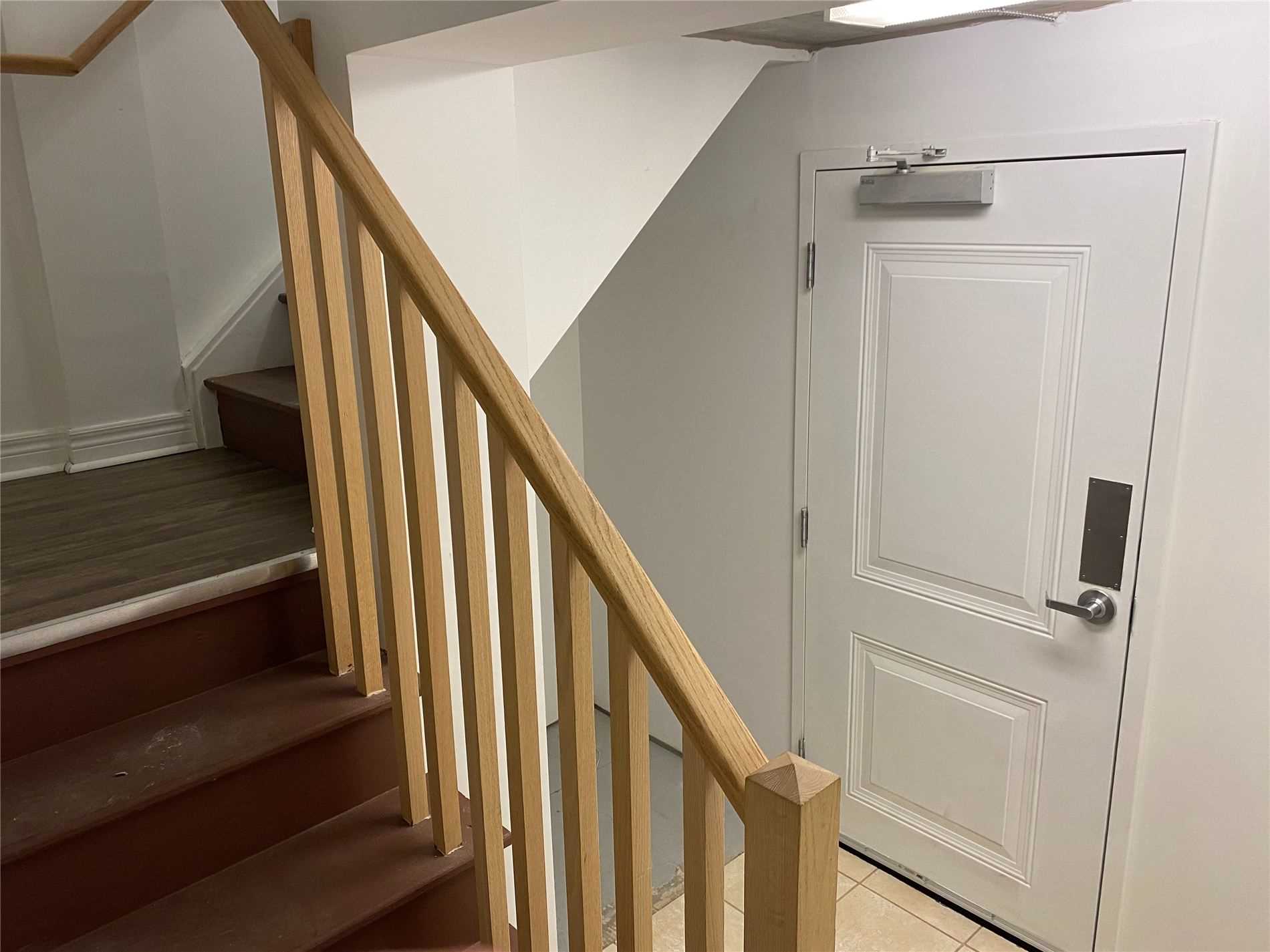 A staircase with wooden handrails and white walls.