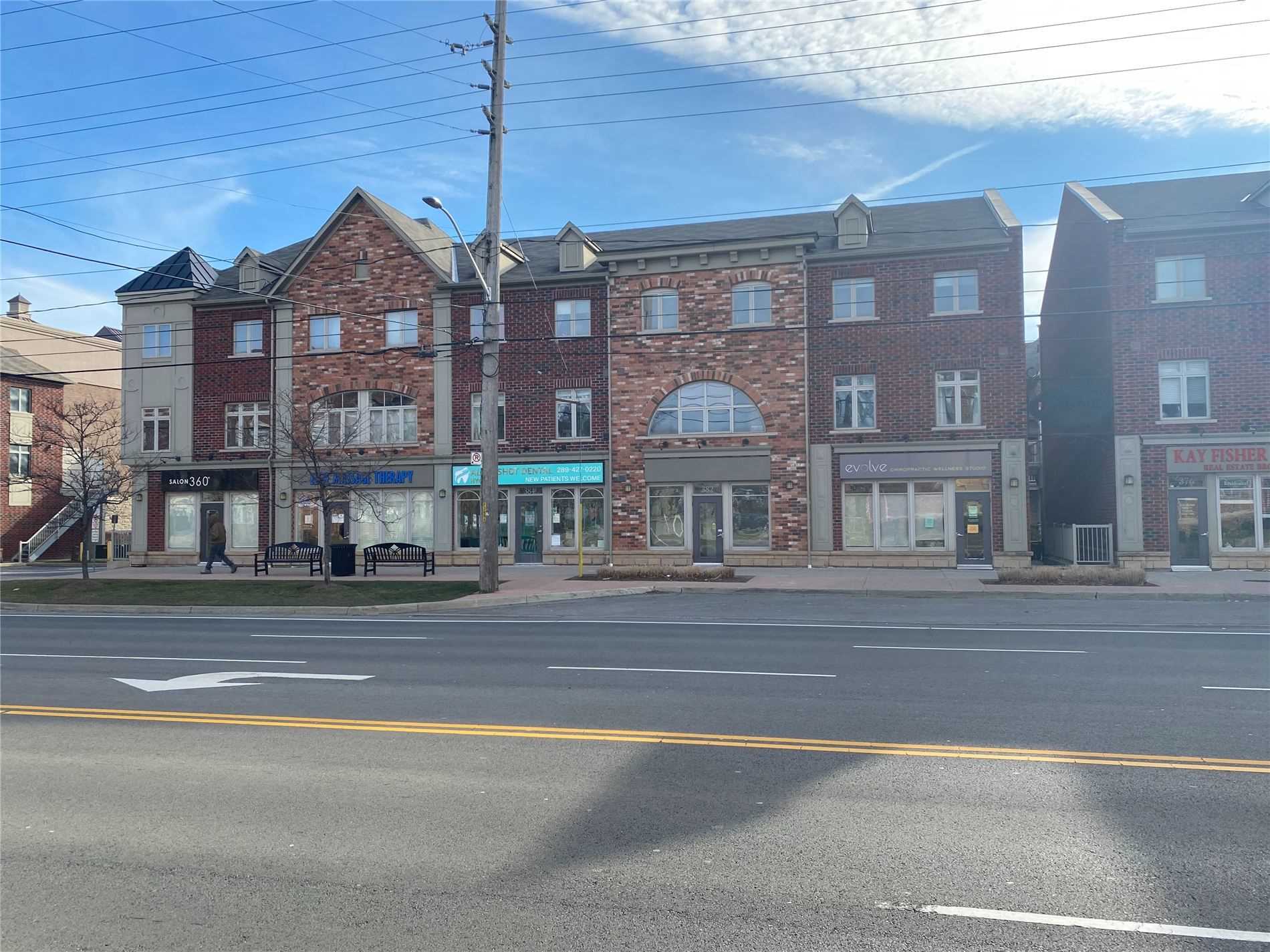 A street view of a building with many windows.