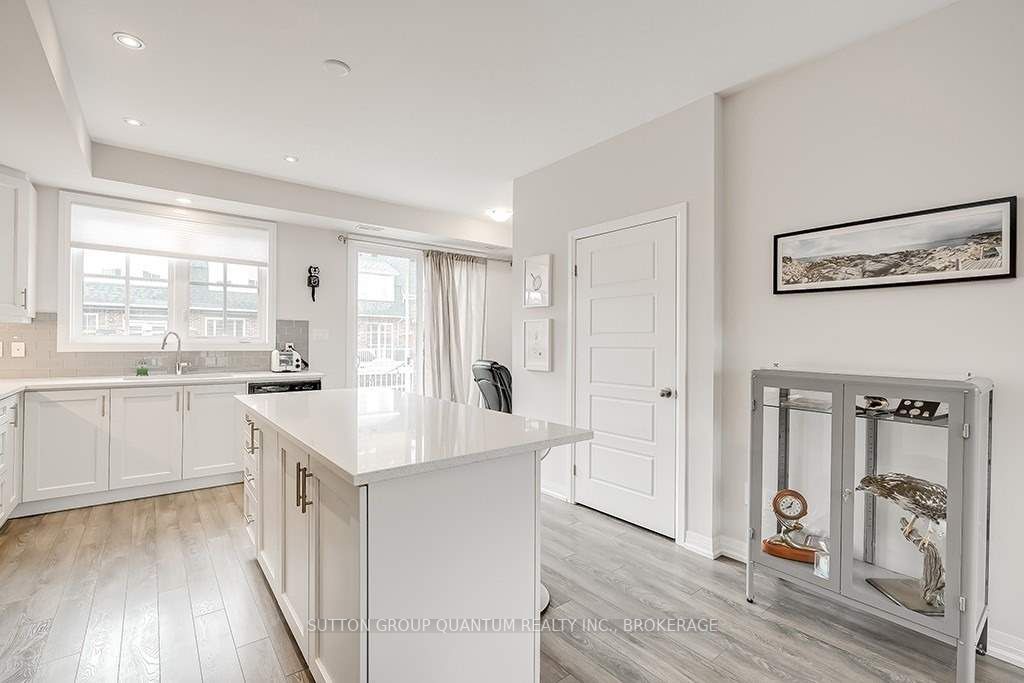 A white kitchen with a large island in the middle of it.