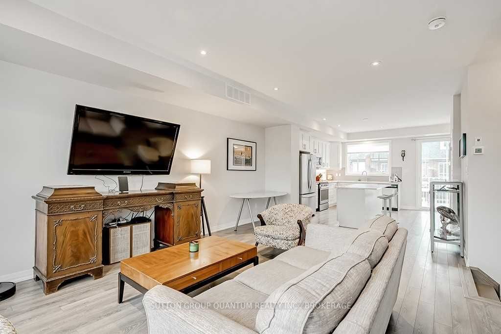 A living room with white furniture and a flat screen tv.