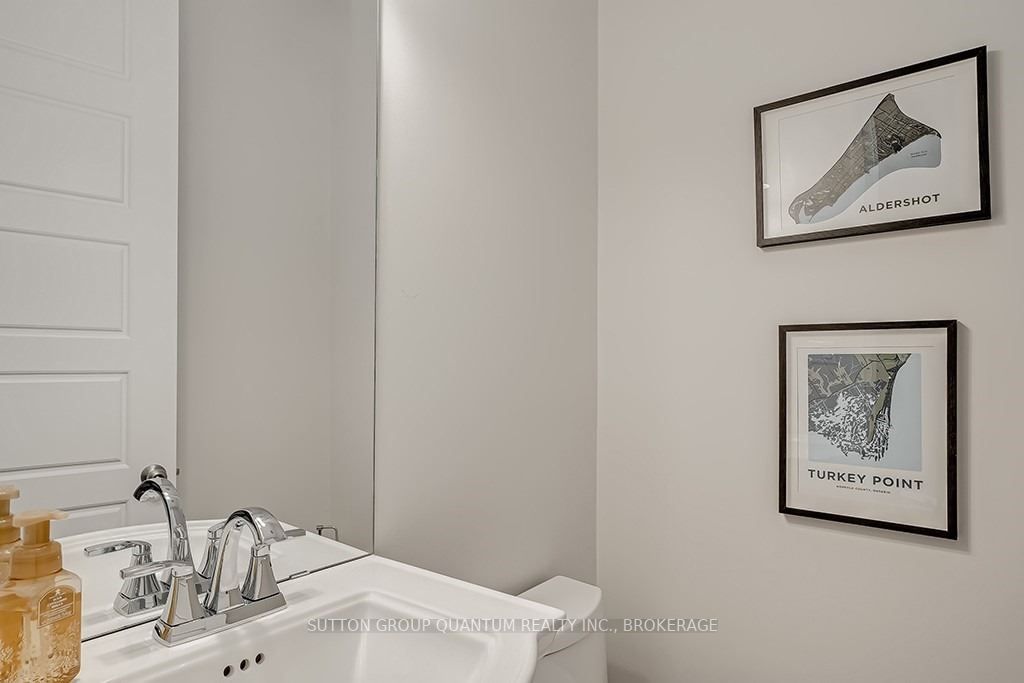 A bathroom with a sink, mirror and picture.