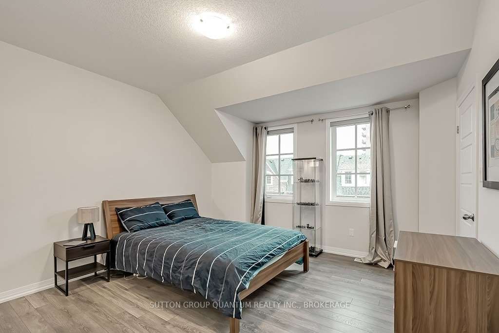 A bedroom with a bed, nightstand and window.