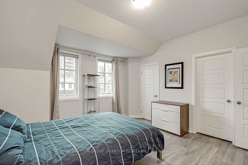 A bedroom with a bed, dresser and window.