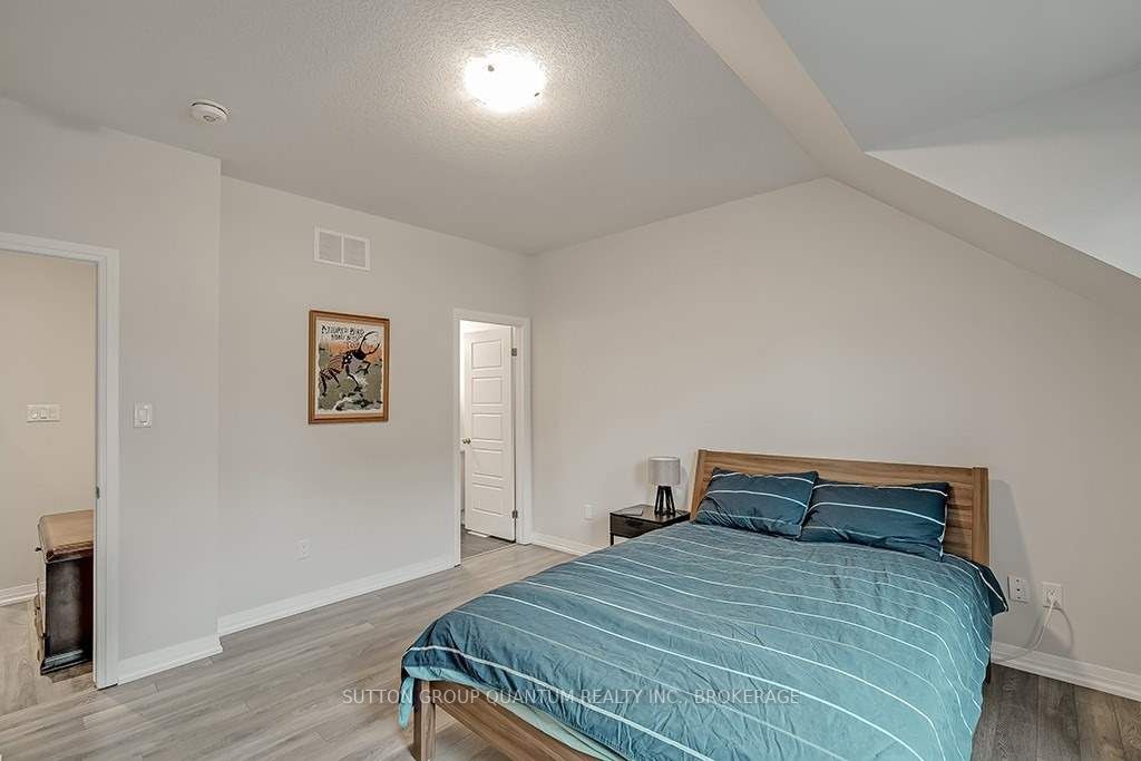 A bedroom with a bed, nightstand and dresser.