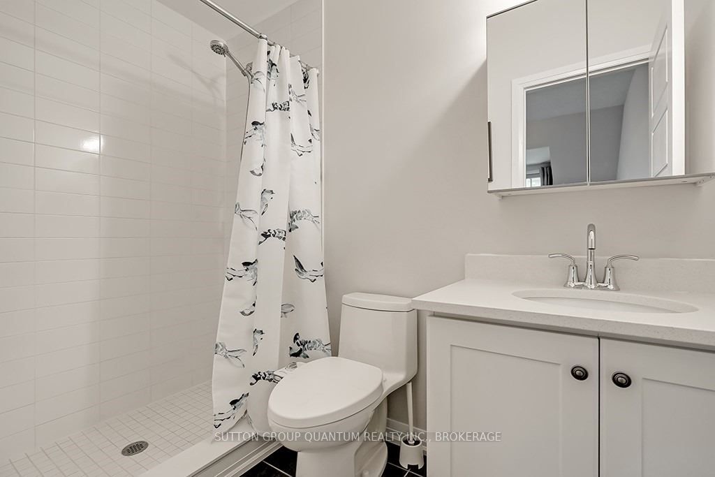 A bathroom with white walls and a shower.