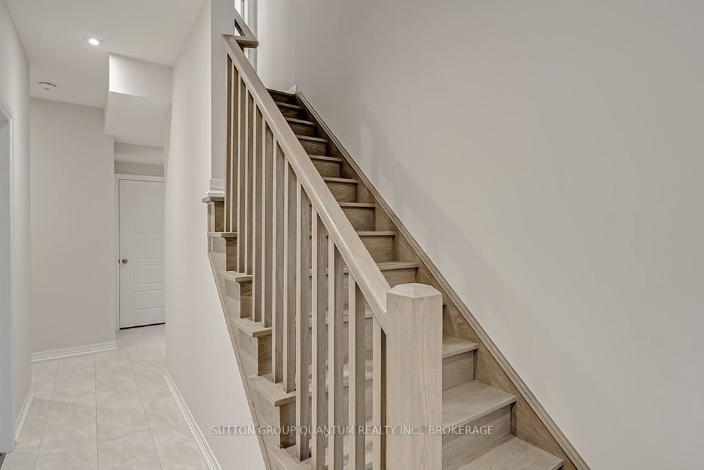 A white staircase with wooden steps and handrails.