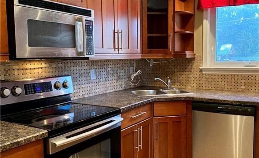 A kitchen with wooden cabinets and stainless steel appliances.