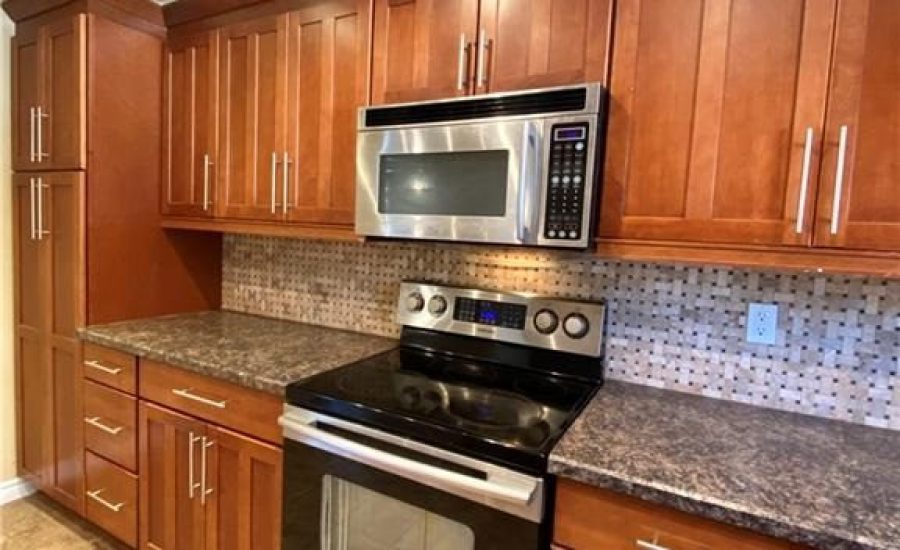 A kitchen with wooden cabinets and stainless steel appliances.