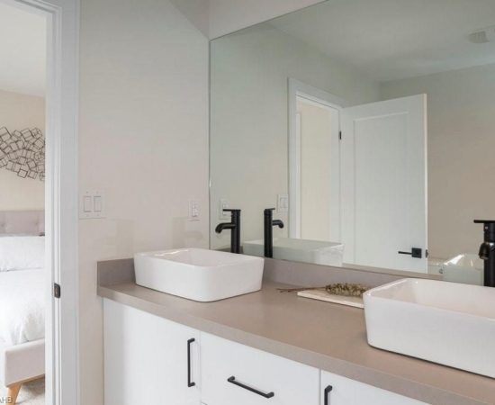 A bathroom with two sinks and a large mirror.