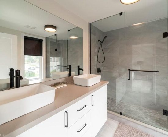 A bathroom with two sinks and a large mirror.