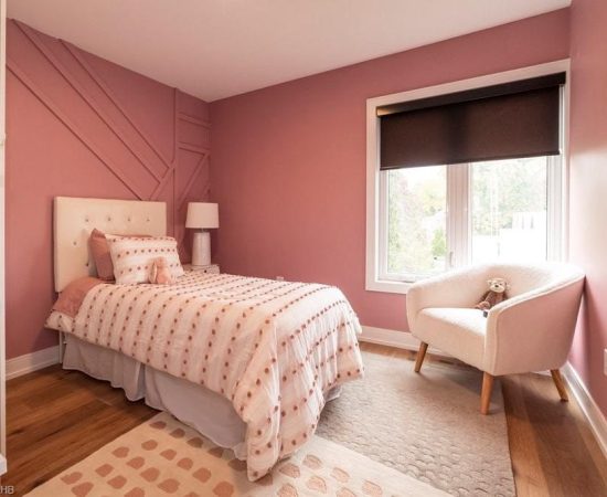 A bedroom with pink walls and white furniture.