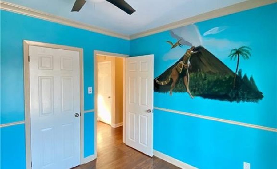 A bedroom with blue walls and a ceiling fan.