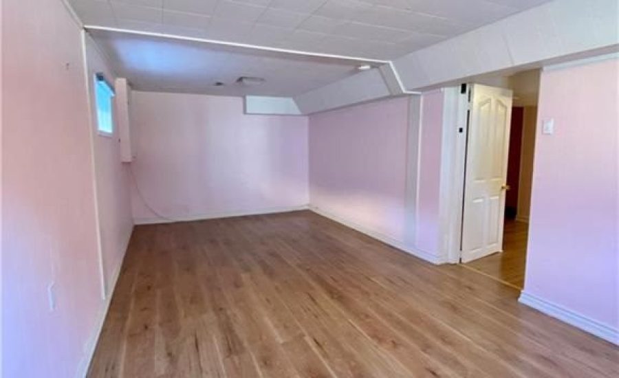 A room with hard wood floors and pink walls.