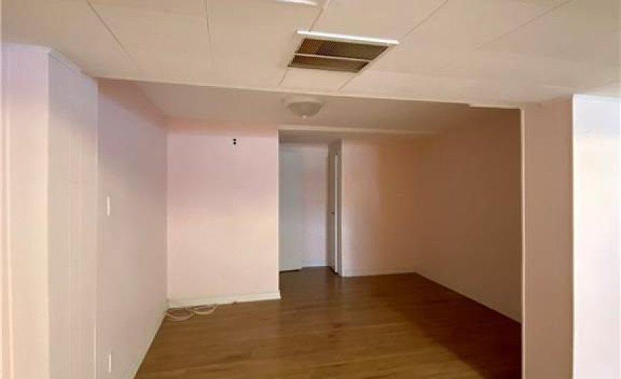 A room with hard wood floors and pink walls.