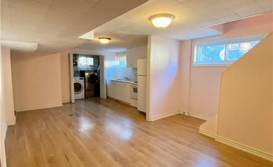 A room with hard wood floors and pink walls.