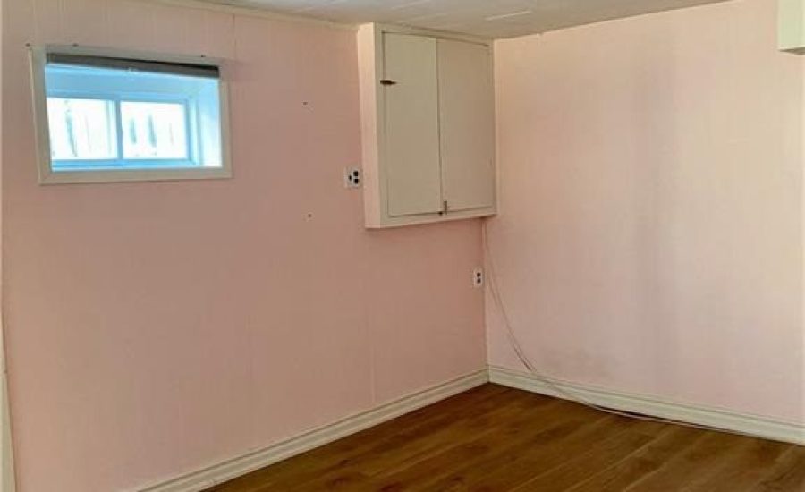 A room with pink walls and wooden floors.