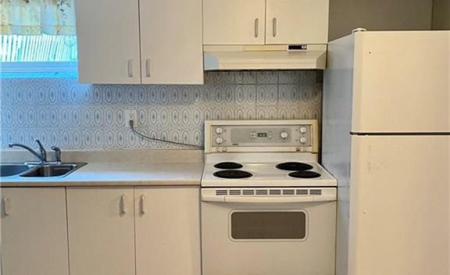 A kitchen with white cabinets and appliances in it