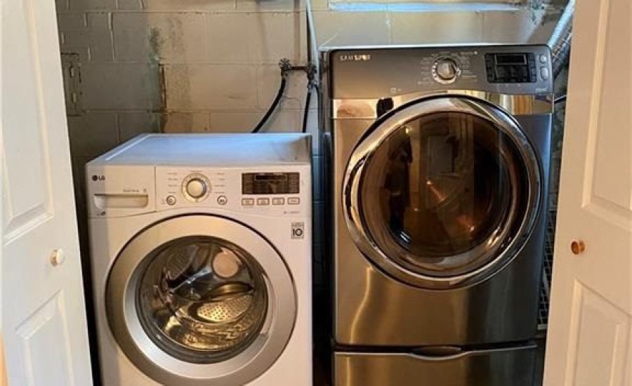 A washer and dryer in the corner of a room.