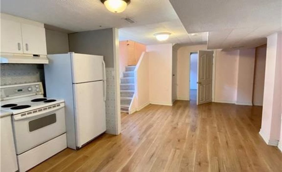 A kitchen with white appliances and wooden floors.