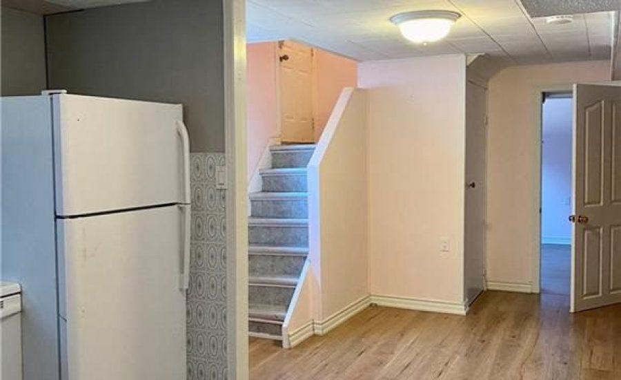 A kitchen with white appliances and wooden floors.