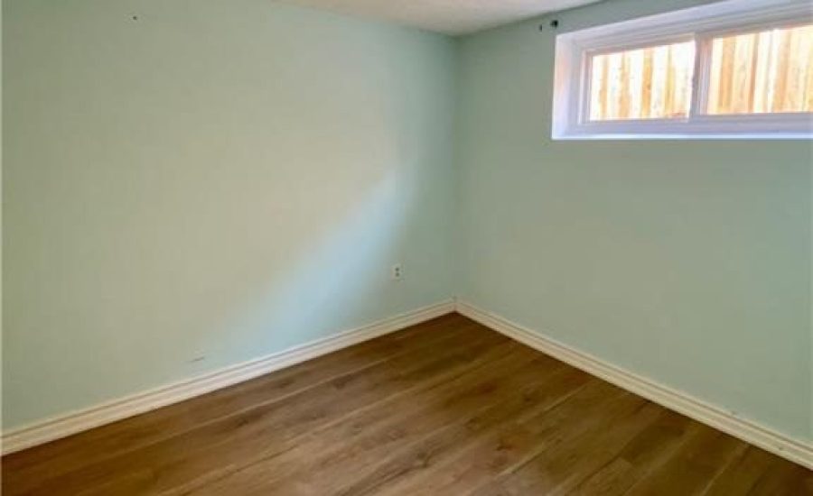 A room with hard wood floors and a window.