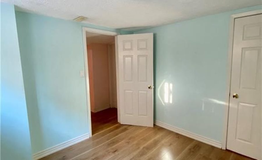 A room with hard wood floors and white walls.