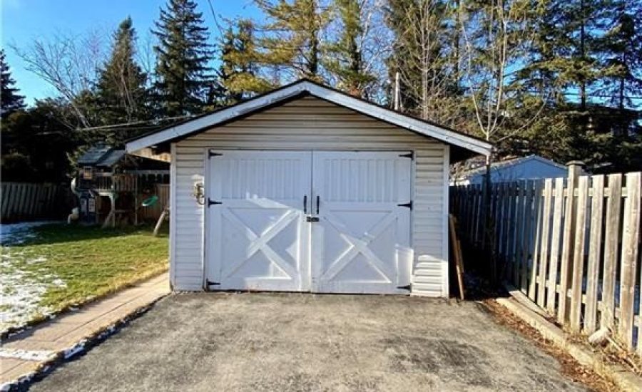 A white garage door is open on the side of the road.