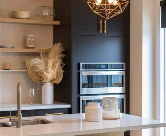 A kitchen with a sink, oven and microwave.