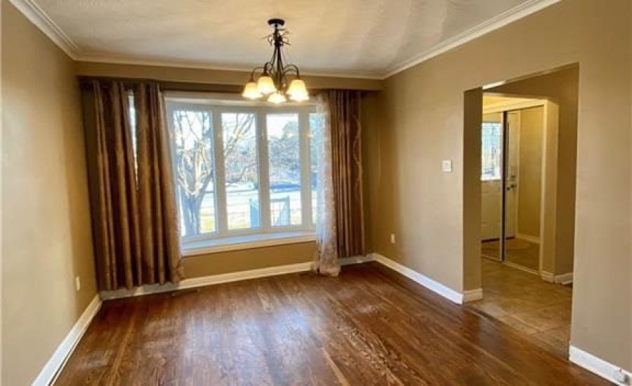 A living room with hard wood floors and a large window.