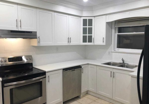 A kitchen with white cabinets and stainless steel appliances.