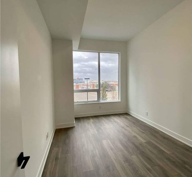 A room with a window and a wooden floor