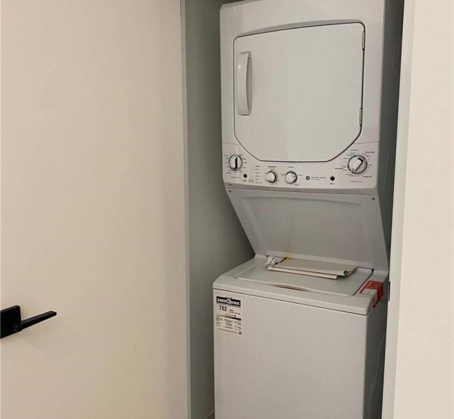 A white washer and dryer in the corner of a room.