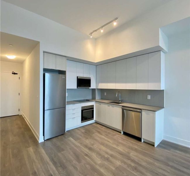 A kitchen with stainless steel appliances and wooden floors.