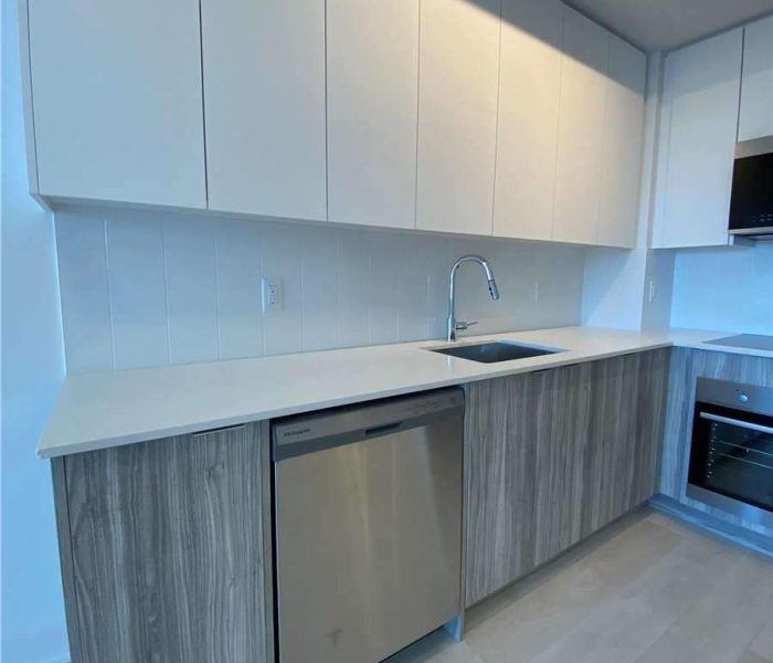 A kitchen with white cabinets and wooden cupboards.