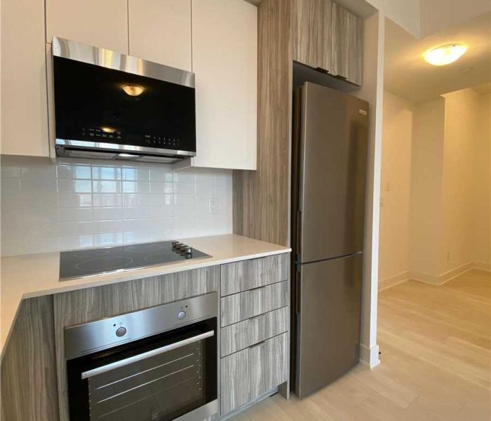 A kitchen with an oven and refrigerator in it