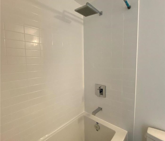 A bathroom with white walls and a tub.