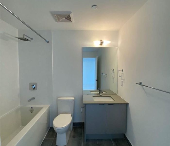 A bathroom with a toilet, sink and bathtub.