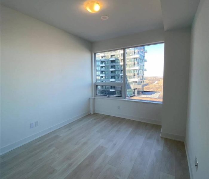 A room with a large window and wooden floors.