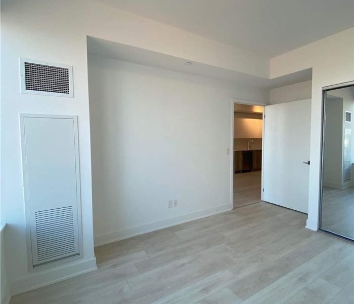 A room with white walls and wooden floors.