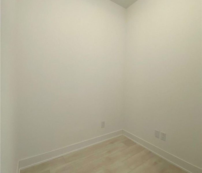 A room with white walls and wooden floors.